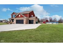 Spacious two-story home with brick facade, attached garage, in-ground pool, and red barn at 6880 W Jennifer Dr, Greenfield, IN 46140