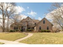 Charming brick home featuring a manicured lawn and winding brick walkway leading to the front entrance at 7806 Ashtree Dr, Indianapolis, IN 46259