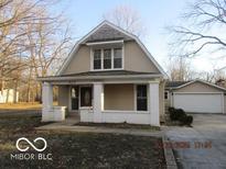 Charming two-story home with a covered front porch, inviting curb appeal, and a detached garage at 929 Gilbert Ave, Indianapolis, IN 46227