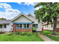 Charming home featuring brick accents, blue trim, and lush landscaping, creating a welcoming curb appeal at 960 Cameron St, Indianapolis, IN 46203