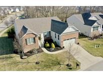 Charming brick and siding home with an attached two-car garage and beautifully landscaped yard at 9695 Wandering Woods Ct, Fishers, IN 46037