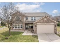 Charming two-story home with a brick facade, attached garage, and well-maintained lawn at 11453 Scheel Ln, Carmel, IN 46032