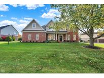 Charming two-story brick home with manicured lawn and mature trees at 11573 Westbury Pl Dr, Carmel, IN 46032