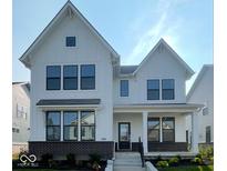 Charming two-story home featuring white siding, black trim windows, brick base, and landscaped front yard at 13610 Grand Abbey Way, Fishers, IN 46037