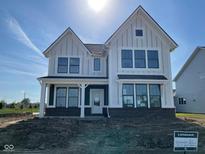 New construction home with a white facade, dark brick foundation, and an inviting covered porch at 13610 Grand Abbey Way, Fishers, IN 46037