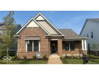 Charming single-story brick home with manicured lawn and inviting walkway leading to the front door at 13634 Grand Abbey Way, Fishers, IN 46037