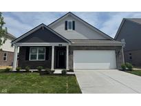 Charming one-story home features brick accents, a two-car garage, and a well-manicured front lawn at 1366 Foxtail Ln, Greenwood, IN 46143
