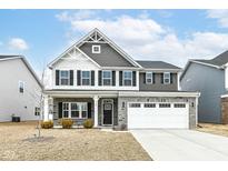 Two-story home features stone accents, a two-car garage, black shutters, and manicured landscaping at 1506 Moose Ridge Ln, Westfield, IN 46074