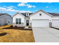 Charming new construction home with a white facade, stone accents, and an attached two-car garage at 1627 Clover Crossing Dr, Greenfield, IN 46140