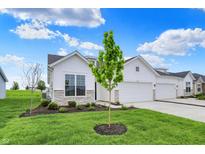 Charming home featuring a two-car garage and inviting curb appeal with stone accents and a well-manicured lawn at 1627 Clover Crossing Dr, Greenfield, IN 46140