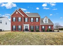 Two-story brick home featuring a well-maintained lawn and classic architectural details under a bright sky at 3236 Springs Way Dr, Bargersville, IN 46106