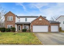 Charming two-story home features a brick facade, attached garage and well-manicured front lawn at 4323 Elkhorn Dr, Westfield, IN 46062