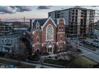 An aerial view of a beautiful brick church next to a modern building at dusk, showing the buildings' architecture at 501 Fletcher Ave # D, Indianapolis, IN 46203