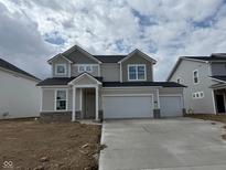 Charming two-story home featuring a three car garage and stylish stone accents, complemented by a cozy front porch at 7156 Firestone Rd, Whitestown, IN 46052