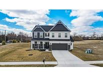 Two-story home with two car garage, white siding, black trim, and landscaping at 7450 Leatherwood Dr, Indianapolis, IN 46259