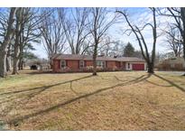 Charming single-story brick home featuring a well-maintained front yard and attached two-car garage at 8615 El Rico Dr, Indianapolis, IN 46240