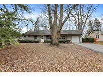 Charming single-story home with a driveway, garage, and mature trees in the front yard at 9520 Broadway St, Indianapolis, IN 46240
