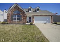 Charming brick home featuring a two-car garage, well-maintained lawn, and dormer windows at 10920 Gate Cir, Fishers, IN 46038