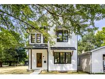Charming two-story home with white siding, black trim, and a welcoming wood front door at 1526 Laurel St, Indianapolis, IN 46203