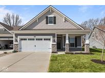Charming home featuring a two-car garage, a well-manicured lawn, and stylish stone accents on the facade at 16771 Cattle Hollow Ln, Noblesville, IN 46060