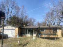 Charming single-story home with a brick facade and attached garage on a sunny day at 2346 Mayfair Dr, Indianapolis, IN 46260