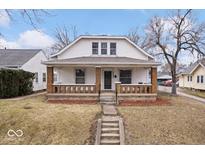 Charming two-story home featuring a covered front porch with brick pillars, offering a cozy curb appeal at 2532 Madison Ave, Indianapolis, IN 46225