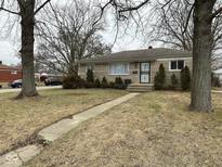 Charming stone home with mature trees and walkway to the front entrance at 3851 N Campbell Ave, Indianapolis, IN 46226