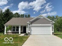 Charming single-story home featuring a two-car garage, well-manicured lawn and classic architectural details at 3885 Berkdale Ct, Columbus, IN 47203
