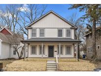 Charming two-story home featuring light-colored siding, gray accents, and a welcoming front porch at 4054 Boulevard Pl, Indianapolis, IN 46208