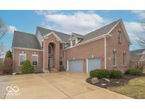 Charming brick home with attached two-car garage and meticulously maintained landscaping on a sunny day at 7823 Beechwood Farms Dr, Avon, IN 46123