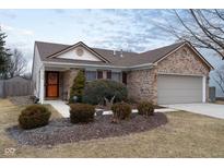 Charming single-story brick home featuring a well-manicured lawn and attached two-car garage at 10154 Holly Berry Cir, Fishers, IN 46038