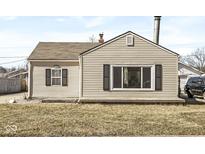 Charming home featuring beige siding, black shutters, and a well-maintained front yard at 103 S Delawanda Ave, Muncie, IN 47303