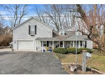 Charming home featuring an attached garage, manicured front yard, and welcoming front porch with a swing at 10730 N Park Ave, Carmel, IN 46280