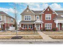 Charming townhouse featuring a covered porch with seating and a combination of brick and siding at 1225 Middlebury Dr, Westfield, IN 46074