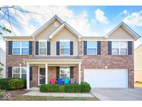 Charming two-story home featuring brick and vinyl siding, a well-manicured lawn, and a two-car garage at 1288 Ivory Ct, Greenwood, IN 46143