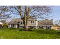 Lovely home exterior with mature trees, offering a blend of brick and siding for classic curb appeal at 220 Pine Dr, Indianapolis, IN 46260