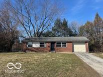 Charming brick ranch-style home with a well-manicured front lawn and an attached garage at 2306 John Glenn Ct, Indianapolis, IN 46229
