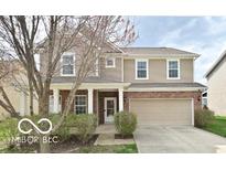 Charming two-story home with brick and beige siding, a covered porch, and an attached two-car garage at 2336 Boneset Dr, Plainfield, IN 46168