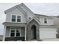 Charming two-story home with gray siding, stone accent archway, and an attached two car garage at 2661 Creek Bank Ct, Columbus, IN 47201