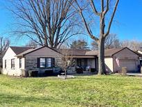Charming single-story home with well-maintained lawn and mature trees on a sunny day at 327 Maxwell Rd, Indianapolis, IN 46217