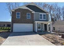 Two-story home featuring a brick facade, gray siding, and a spacious two-car garage at 3825 Windstar Way, Columbus, IN 47203