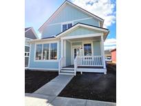 Charming light blue two-story home with a welcoming front porch and large windows at 5421 Upper Garden Way, Zionsville, IN 46077