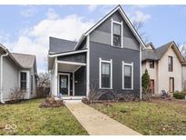 Charming two-story home featuring dark siding, white trim, and a welcoming front porch at 548 N Highland Ave, Indianapolis, IN 46202