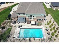 Stunning aerial view of backyard featuring a large swimming pool, patio with outdoor kitchen, and well-manicured lawn at 5683 Oakmont Blvd, Bargersville, IN 46106