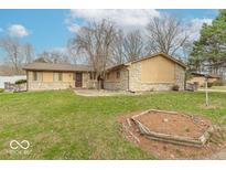 Charming single-story home with a stone and wood facade, complemented by a spacious front yard with mature trees at 5982 Oak Hill East Dr, Plainfield, IN 46168