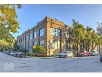 Brick apartment building featuring large windows, mature trees, and street parking at 735 Lexington Ave # 1, Indianapolis, IN 46203
