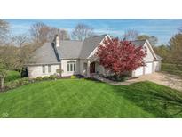 Well-maintained brick home with a lush green lawn, beautiful landscaping, and attached two-car garage at 7472 Windridge Way, Brownsburg, IN 46112