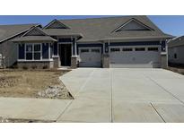 Charming single-story home features a two-car garage, blue siding, and stone accents at 9423 Abner St, McCordsville, IN 46055