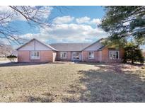Charming single story brick home, featuring a well-manicured lawn and symmetrical architecture at 10709 E County Road 100 N, Indianapolis, IN 46234