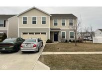 Charming two-story home featuring an attached garage and well-maintained front yard and two parked cars at 215 Traditions Pass, Greenwood, IN 46143